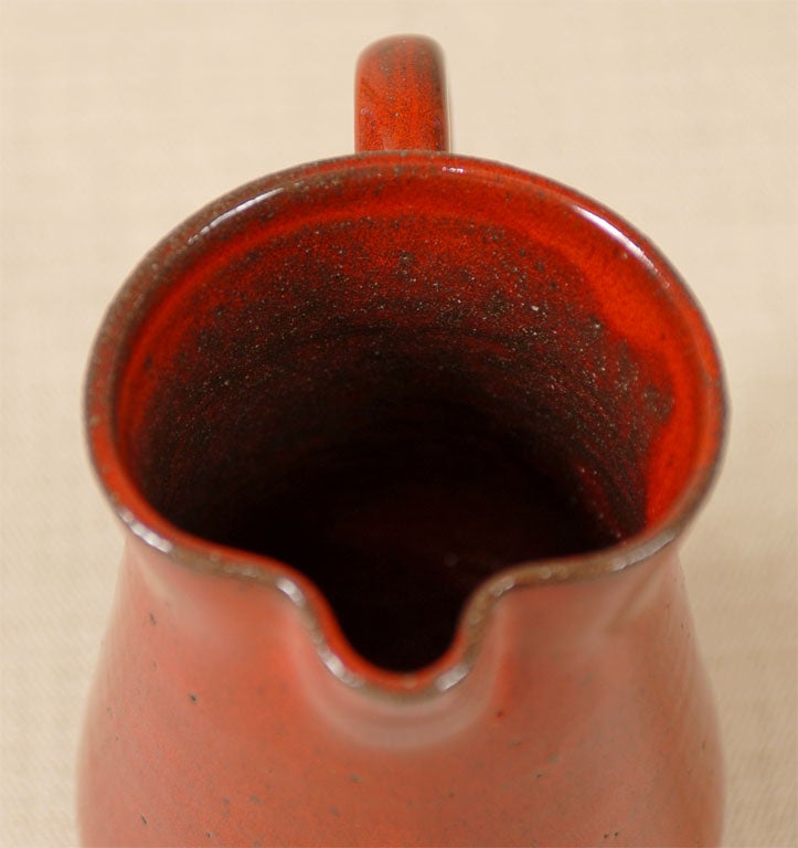 A bright red glazed pottery pitcher by North Carolina Cole Pottery artist, Kenneth George. Inscribed on the bottom 