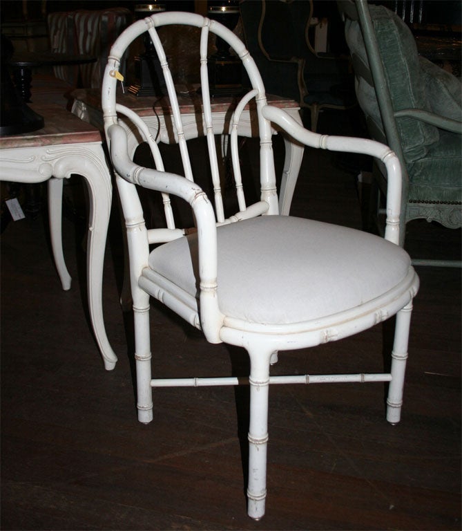 White painted carved wood faux bamboo armchairs with attached slip cushion from Paris, 1960s. Price is for one pair. Six chairs total are available.