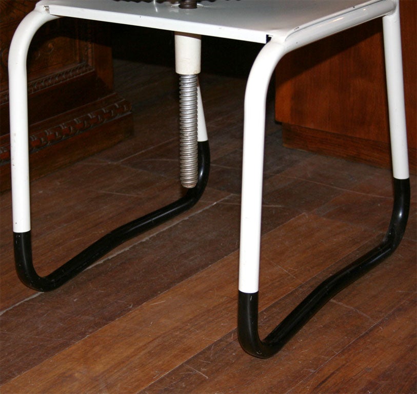 Great American-designed dentist chair with a two-color lacquer metal frame, with cast aluminum adjustable arms and headrest.  Seat height adjusts on treaded rod, seat and back upholstered in original black vinyl.