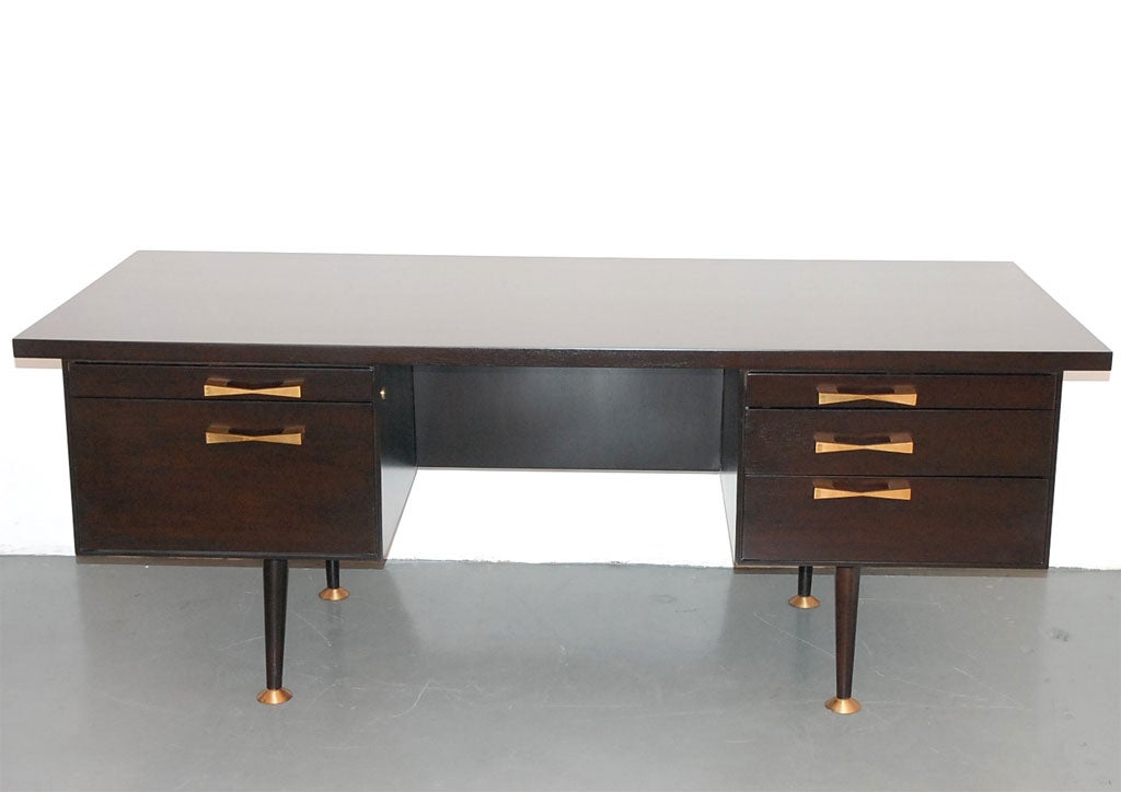Large, stately desk by the renowned Leopold Company of Burlington, Iowa.  The solid brass drawer pulls and feet are great accents to the deep, richly stained oak.