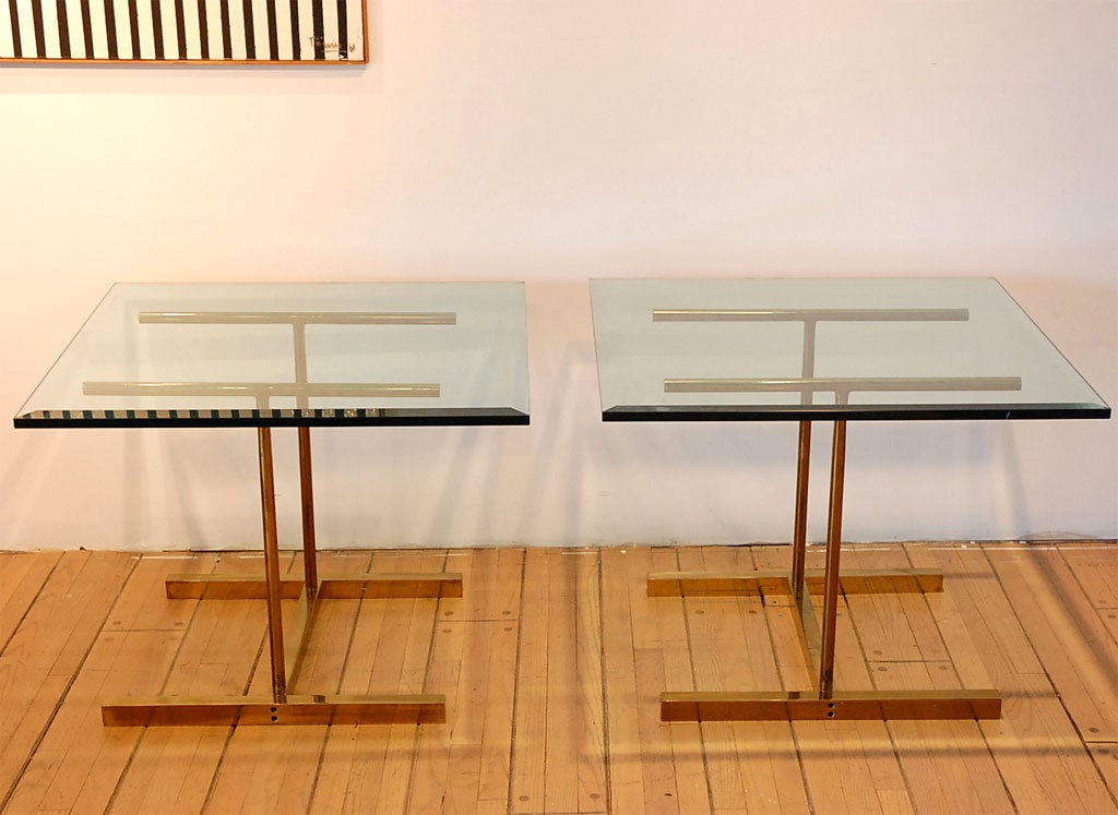 Pair of large brass end tables with beveled glass tops, in the manner of Ward Bennet or Cedric Hartman.  Expertly detailed.  Measurements of table bases are 20 1/2