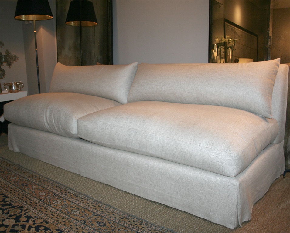 Armless sofa designed by Antony Todd and covered in beige linen.