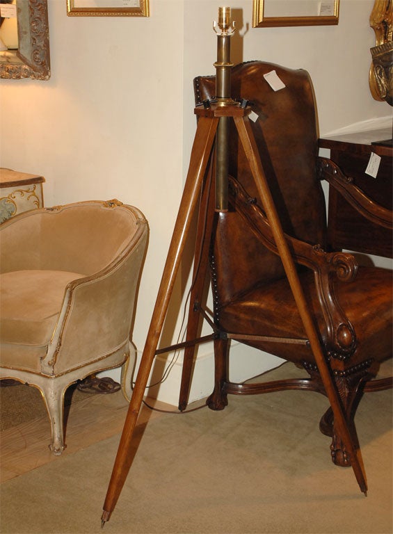 A vintage wood and brass surveyor's tripod made into a lamp.