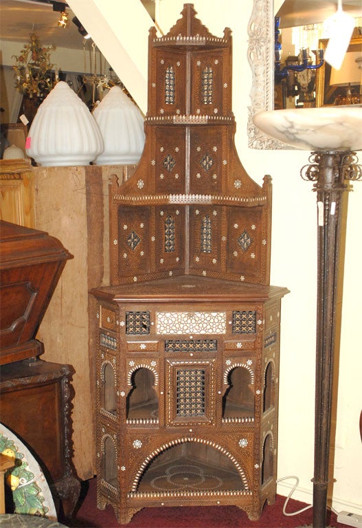 Classic Moorish style two piece walnut corner cabinet with mother of pear1 inlay.  The depth below is from the corner to the front edge.