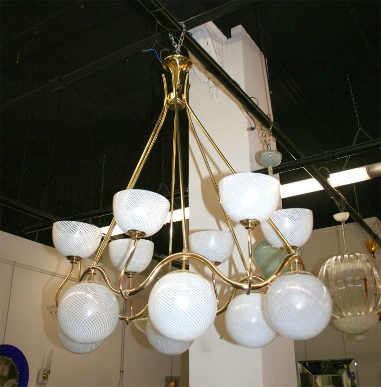 Large Venini twelve-light chandelier with reticello shades, made in 1940 in Venice. Handmade brass frame, very unusual art deco form, great quality.
