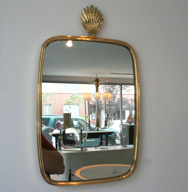 Elegant, beautifully scaled pair of German brass mirrors <br />
with palm frond finials. 1930's. Superb Condition.