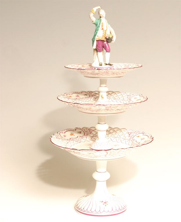 This wonderful three-tiered Meissen dessert stand is decorated with hand-painted floral reserves and pierced graduated plates with magenta borders. Perfect on a sideboard, filled with fruit or desserts, the focal point of a buffet or just a
