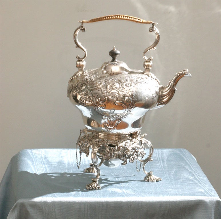 A fully hall marked George III style hot water kettle with<br />
repousse and engraved decoration.