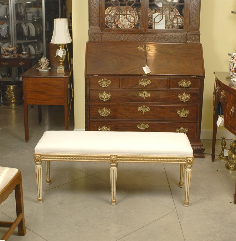 A Louis XVI Style Reproduction giltwood bench upholstered with canvas