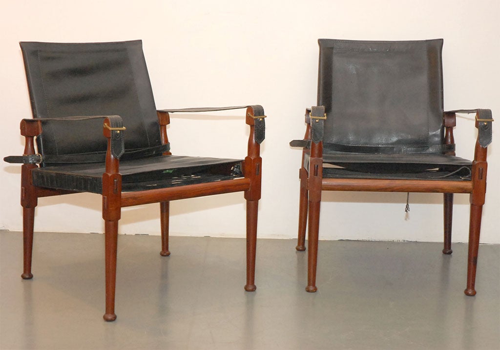 Handsome pair of safari chairs with rosewood and leather.  Great patina and scale with buckle detailing.