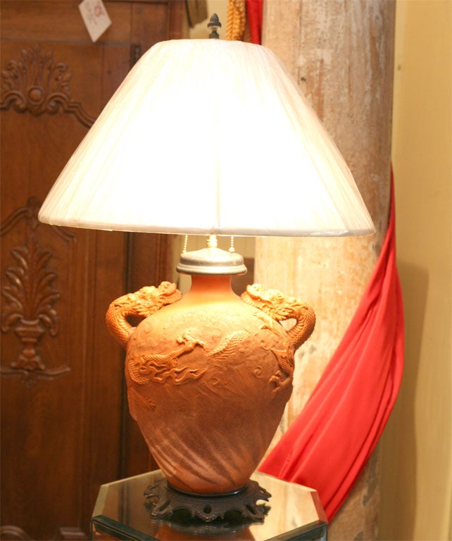 A TERRACOTTA VASE MADE INTO A LAMP, IN THE 1920'S, ON A PATINATED, BRONZE BASE.