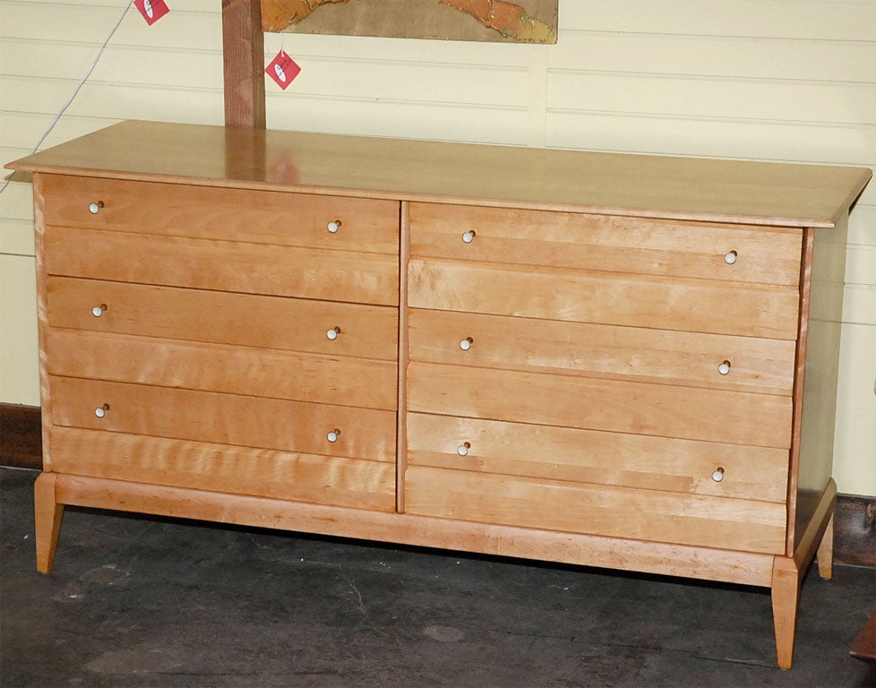 Superb example of American mid-century craftsmanship.  This 6-drawer dresser with fine attention to line and balance, shows the solid tiger maple to perfection.  Drawer pulls are brass and white lacquer.