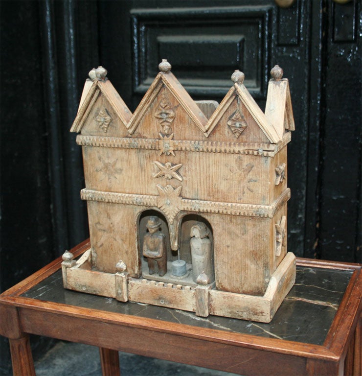 Weather box in the form of a house with carved figures of a man and a woman who rotate in and out forecasting the weather.