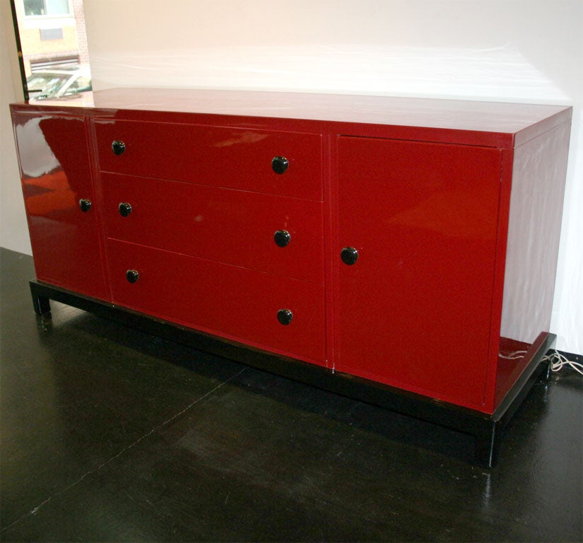 1950's Widdicomb/Robsjohn-Gibbings credenza finished in beautiful Chinese red lacquer. Base and handles are finished in black lacquer.