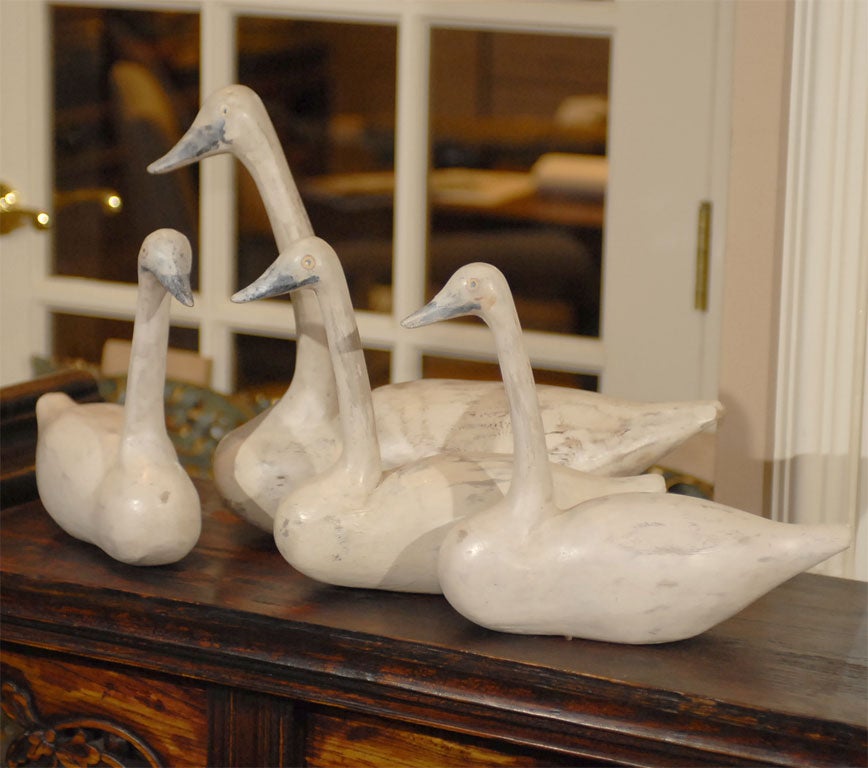 One large and three small hand carved and painted primitive wooden swans.  Large swan costs $95.00 and measures: 16