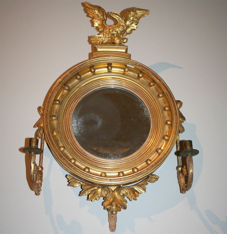 Round gilt mirror with candleholders.