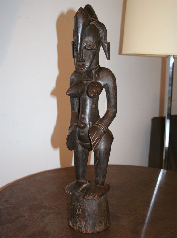 West African (Ivory Coast) carved wood sculpture depicting a female figure of religious heritage from the Senufo tribe.