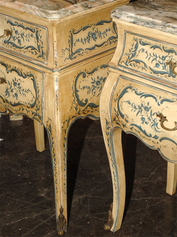 BEAUTIFULLY PAINTED TWO DRAWER SIDE TABLES WITH VARIGATED MARBLE TOPS. UNUSUAL IN THAT THEY ARE BOMBE SHAPED ON THREE SIDES.VERY NICE BRONZE PULLS AND SABOTS.