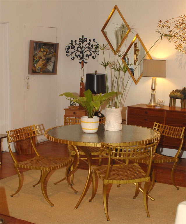 Incrediably chic klismos chairs and matching dining table. Cast aluminum with gilt enamel finish, made by Thinline. The perfect Palm Springs outdoor or indoor dining set.