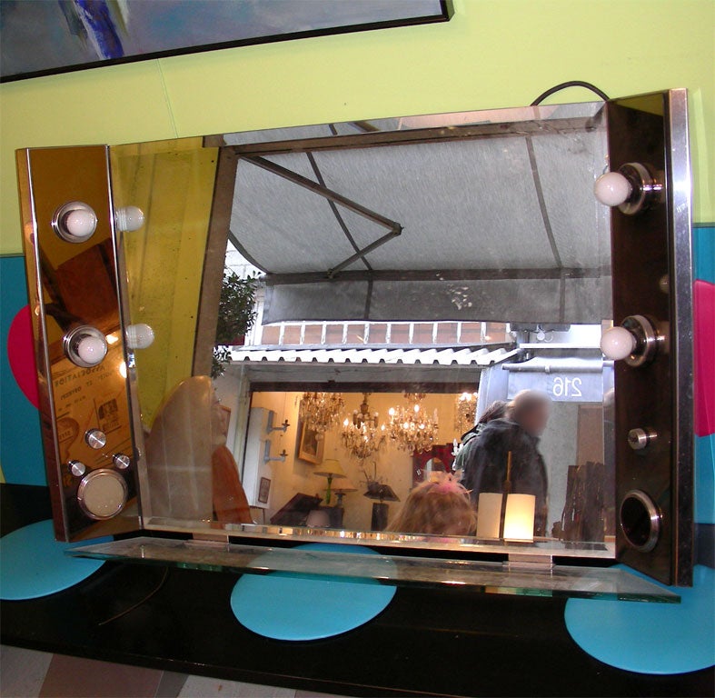 1970s mirror from a dressing-room in the Moulin Rouge in Paris. Bevelled mirror set into a chromed metal structure, with smoked mirror and glass panels. Audio system incorporated, as well as a chronometer which used to indicate to artists how much