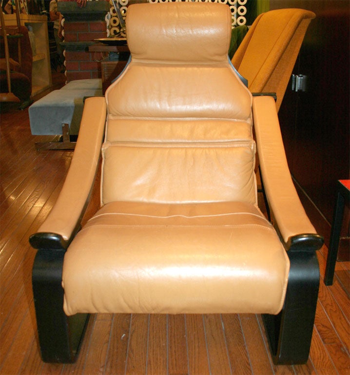 Two armchairs, each with a black bentwood frame and cognac leather seat, back, and arms; priced individually.