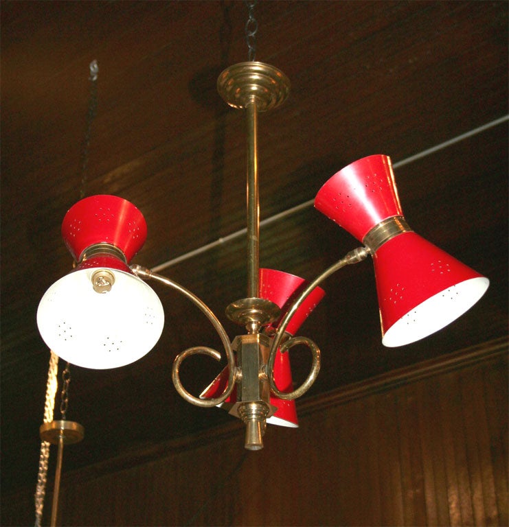 French brass chandelier with three red painted metal conical shades. Mid Century Modern.