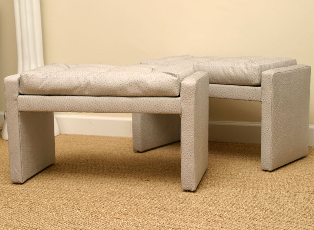 Pair of straight edged benches in soft ice grey faux baby ostrich. Six button tufted top cushions. Original retail price was $4,800. SALE