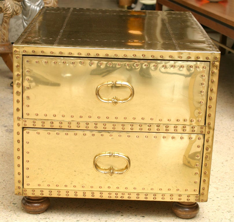 Wooden 2-drawer chest clad in gleaming brass attached with copper rivets. Made in Spain.`