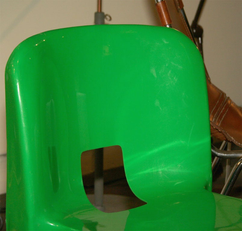 Modern pair of green plastic chairs by Italian designer Joe Colombo. These chairs, although they look small, are the perfect size for an adult. These chairs would be at home on a balcony or patio as well as inside.