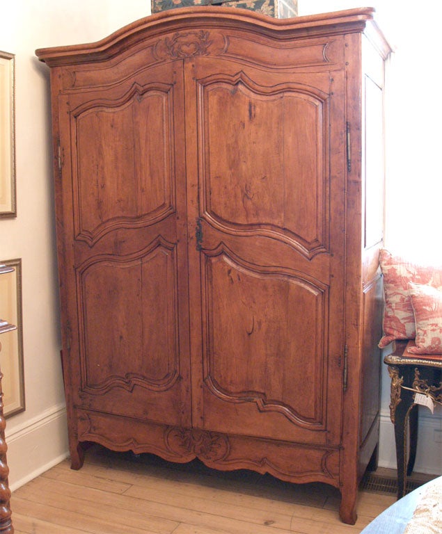 Two door armoire, with carved heart with laurel leaves at top of crest and laurel leaves at bottom.  Three interior shelves.