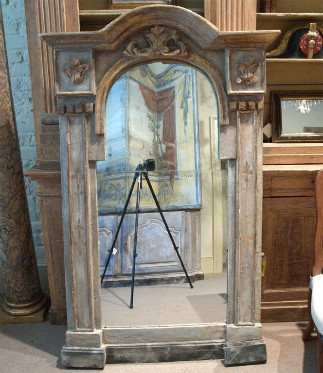 A 19th century French painted neoclassic mirror with carved and gilded accents.