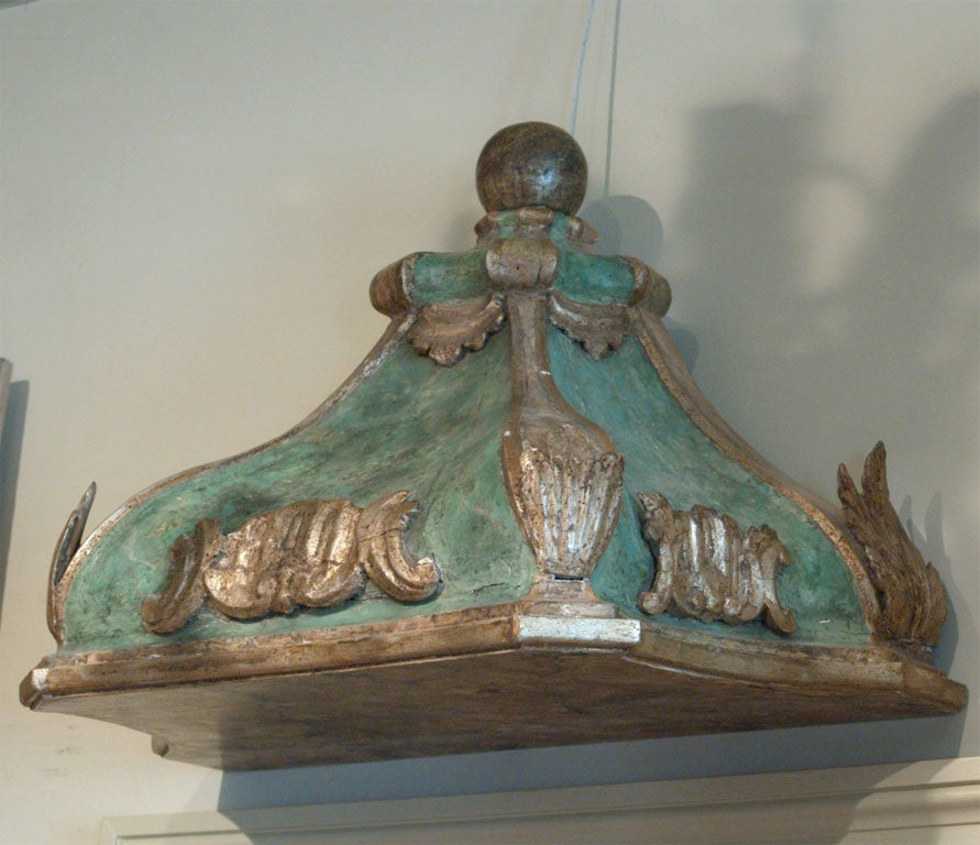 A carved, painted and gilded wood ciel du lit (bed corona) of the period. Gilded leaves, scrolls and drapes are set against a blue green painted background.