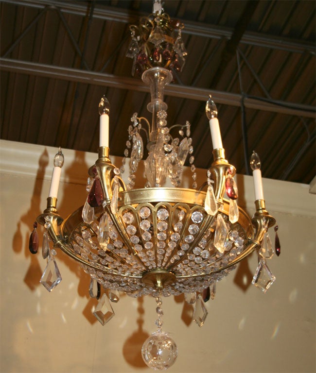 A French Art Deco bronze ten-light chandelier with Baccarat style central column ending in a bowl shaped frame of beaded crystals and bronze supports six of which forming the candle arms, three interior lights, one light in top crown, with large