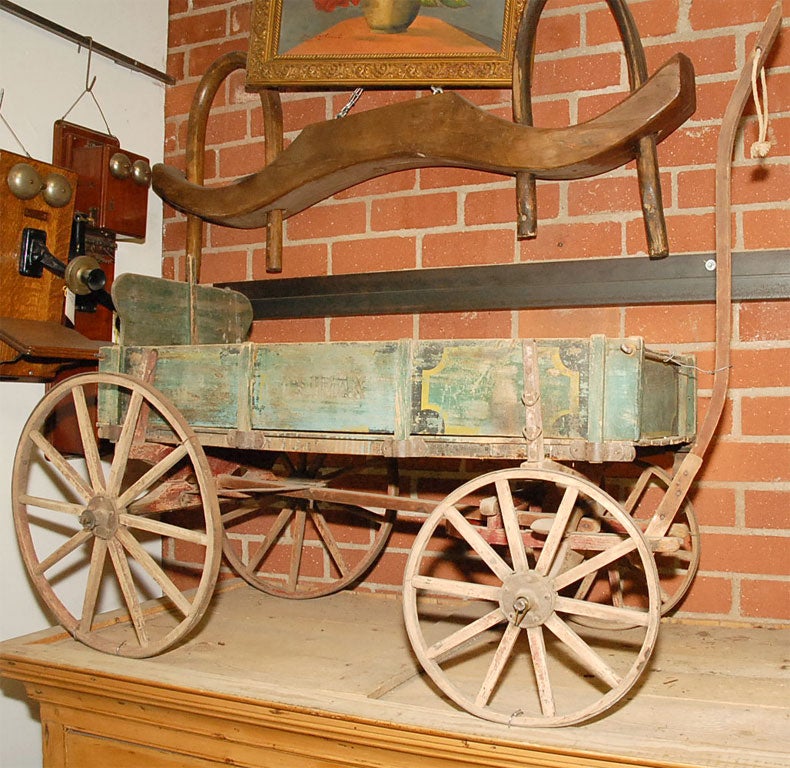 This old wagon has distressed and worn painted elements. The name Climax may be seen on one panel. We also have the original slides that may be afixed to use the wagon on snow. This is an old timer and would fit nicely into an earlier setting. 