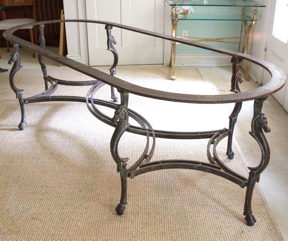 Spectacular table base in wrought iron; the six cast legs of seahorse inspiration; lovely paired curving stretchers; hoof feet