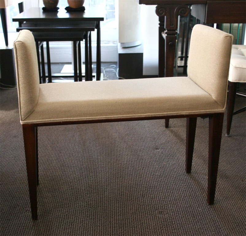 Upholstered Bench with Low Arms and Tapered Legs.