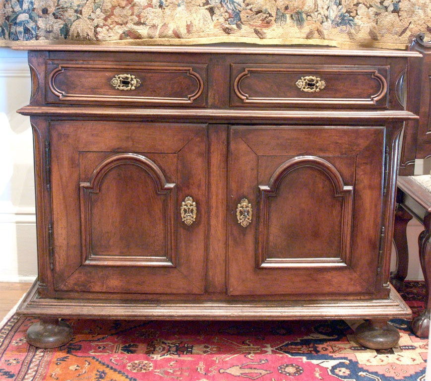 Small Scale Italian 17th century walnut buffet with bun feet and arched doors with original hardware.