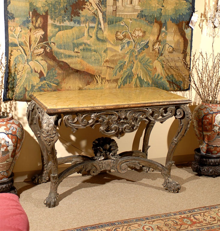 A rare and fine Venetian console table from the late 17th century. The carved and silver-gilt wood frame is composed of a pierced frieze with scrolls and fruit carvings, mounted on four Baroque cabriole legs, these connected by a stretcher with