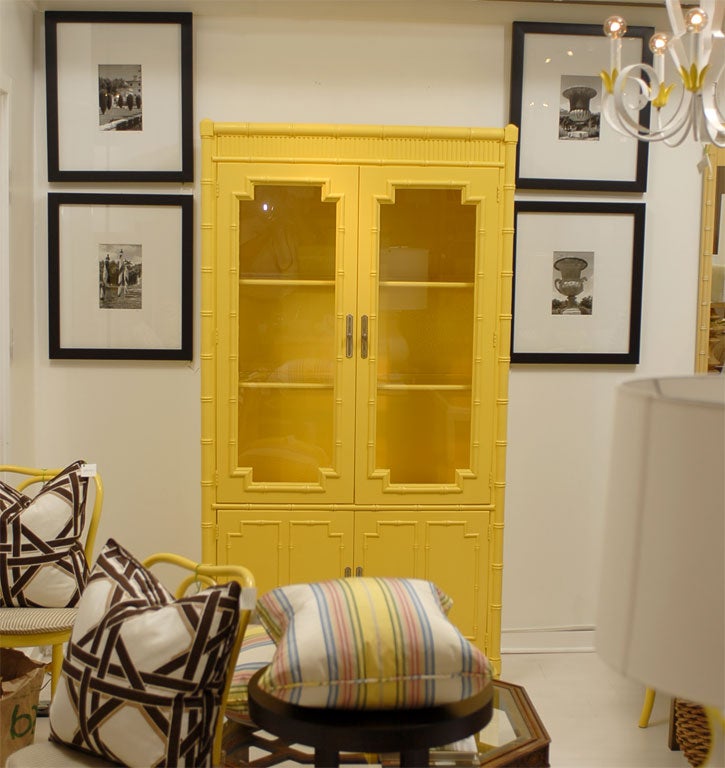 Glass upper cabinet doors show the two glass shelves.  Everything is original condition except the newly painted bright yellow semi gloss color.  Two shelved below are great for storage. Unique faux bamboo detail around glass, top and base