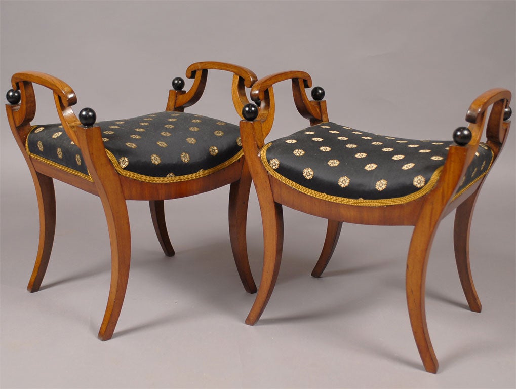 A pair of early 19th Century fruitwood window benches with ebonized details atop graceful curved legs.  

For many other fine antiques, please visit our website.