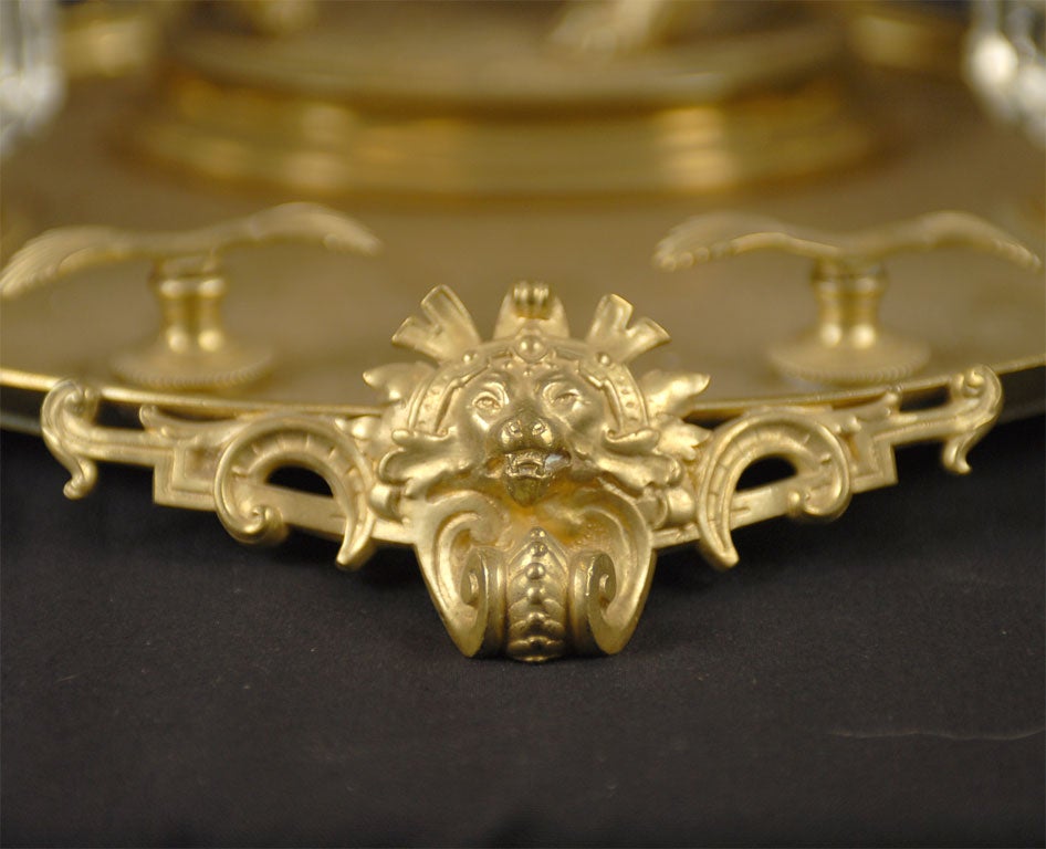 A gilt-bronze and crystal desk set of the Napoleon III period. Composed of two crystal ink wells, a raised pen tray, and a sculptural depiction of a female figure riding a tiger. All pieces are rendered in detail, and mounted on a formed gilt-bronze