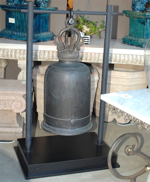 A very large and decorative bronze temple bell hanging on a later custom stand.  A great door bell!