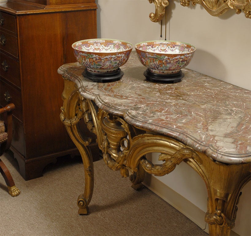 A fine pair of Chinese export porcelain Punch Bowls, dating from the late 1700's, and featuring painted and gilt decoration in the "Mandarin Palate". The exterior with alternating vignettes of stylized court scenes and floral arrangements,