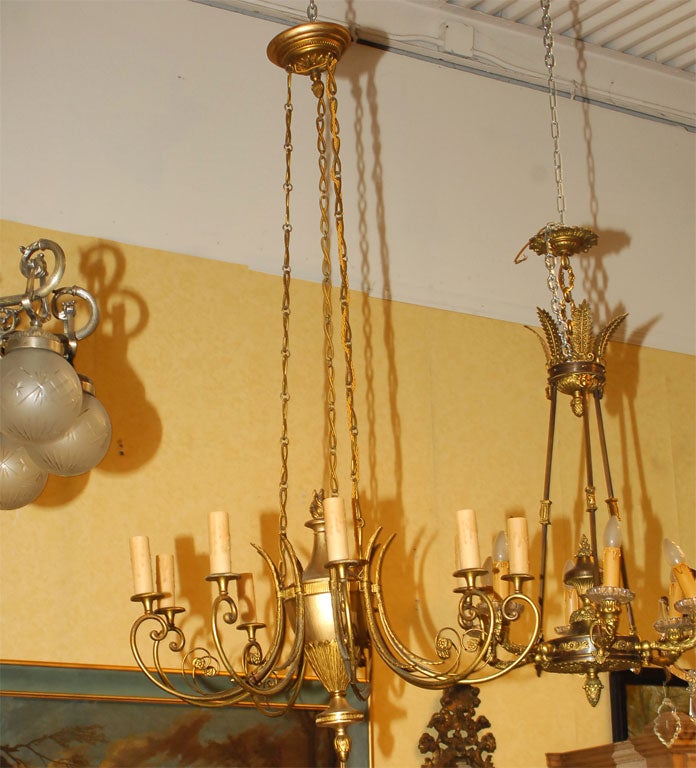 AN ELEGANT GILDED METAL NEOCLASSICAL STYLE EIGHT ARM CHANDELIER.