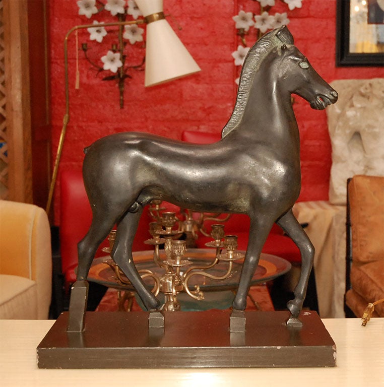 Elegant sculpture of horse with dark brown patina.