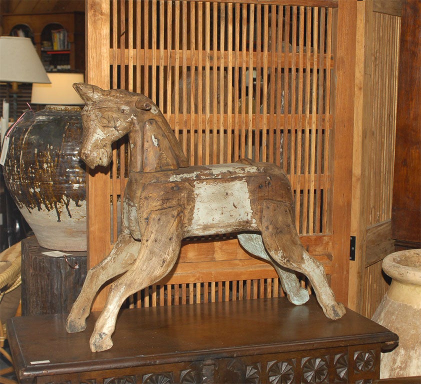 Painted pine carousel type horse orobably originall on a base with wheels. Has original remains of the horse hair tail and much pigment remaining.<br />
A wonderful folk art item from  Spain