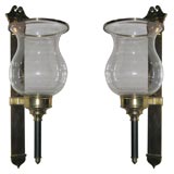 A large pair of brass and glass hurricane wall sconces
