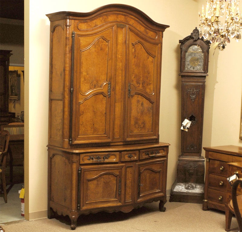 A serpentine-fronted Buffet deux corps in walnut, dating from the mid-to-late 18th century, and originating in France. The upper section with an arched form surmounted by a deep molded cornice, the two hinged doors concealing a series of adjustable