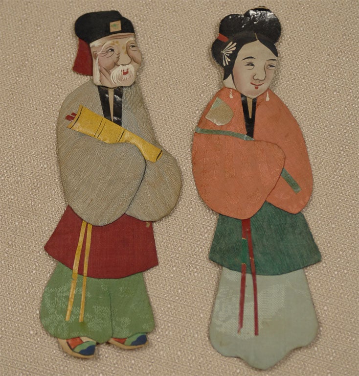 A fabulous set of handmade silk and paper dolls.  Each is handmade from paper and dressed in silk, then painted with details.  They are each different: with varying dress and facial features. These were probably stick puppets given the areas on the