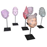 A collection of Thai puppet heads on stands.